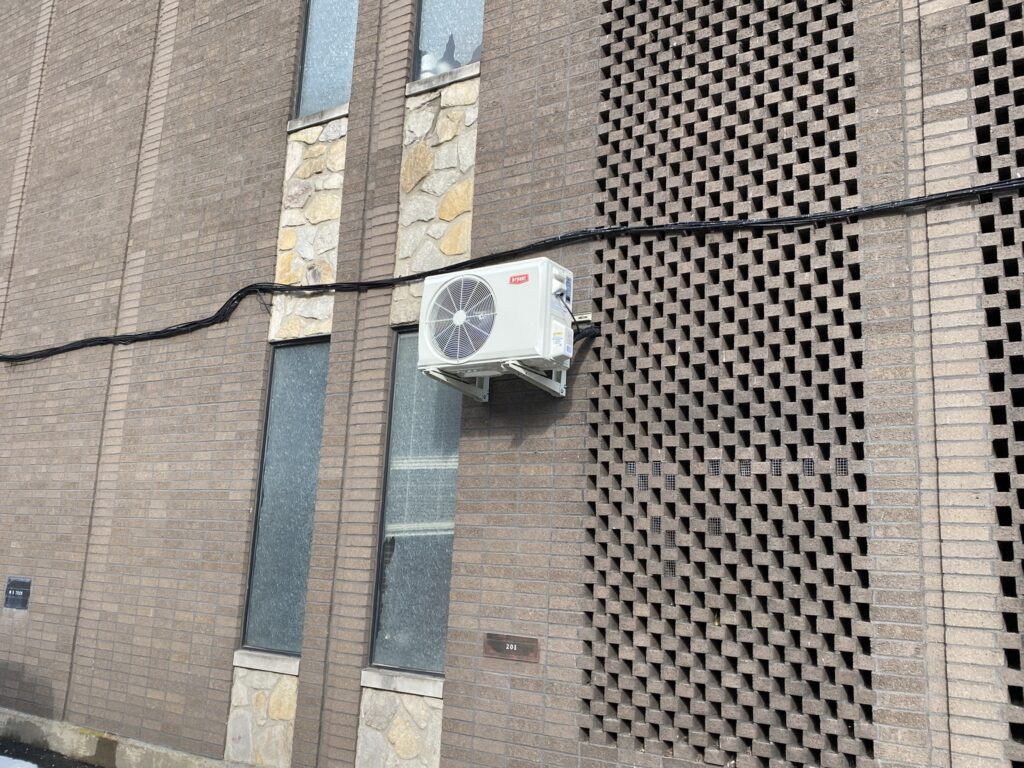 Bryant mini-split outdoor unit mounted on the exterior of a commercial building, providing efficient heating and cooling with minimal space requirements.